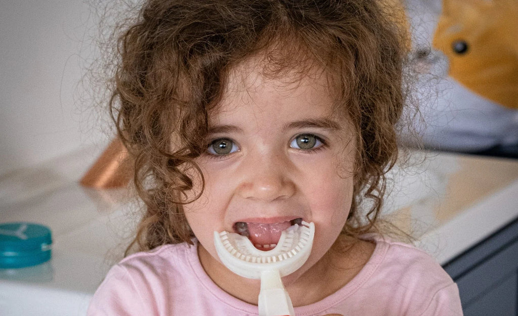 view of a kid trying the New Y-Brush KidsBrush Sonic Electric Toothbrush (4-12 years old)